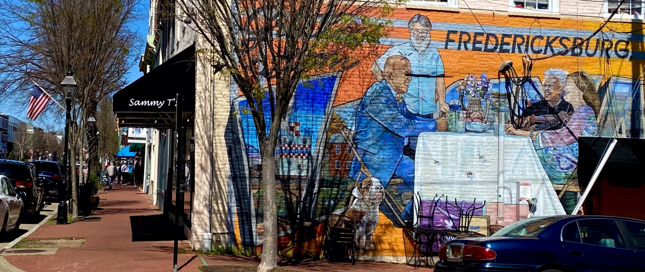 Fredericksburg, VA mural on Sammy T's restaurant with people sitting at a table that says.